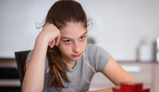 Young girl showing signs of eye strain and difficulty concentrating