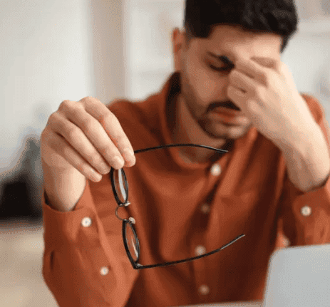 man with eye strain glasses